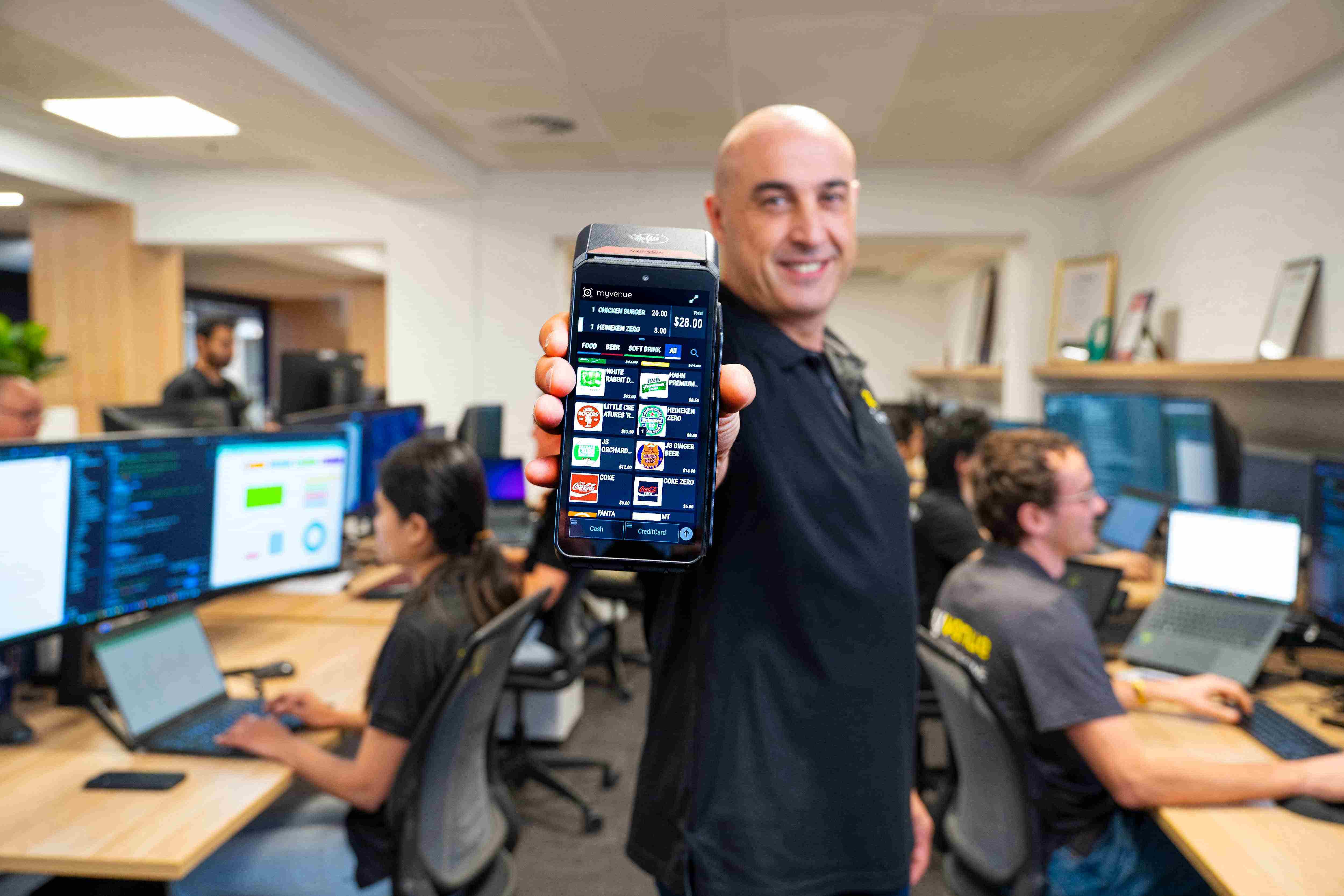 MyVenue CTO David Ialeggio holding a handheld POS device with MyVenue's POS software